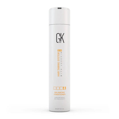 A tall white cylindrical bottle of GK Cosmetics Hair Taming System 1 with Juvexin Balancing Conditioner, shown on a clean white background.