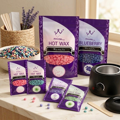 A wax melt kit display on a light marble countertop, featuring purple bags of Sensuality brand hot wax in pink, blueberry, lavender, and green flavors, alongside a black wax warmer and bowls of colorful wax melts.