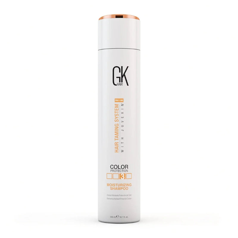 A tall white cylindrical bottle of GK Paris Juvexim Hair Taming System 4 Color Protection Moisturizing Shampoo, featuring a metallic rose gold cap and orange and black text on the front, set against a plain white background.