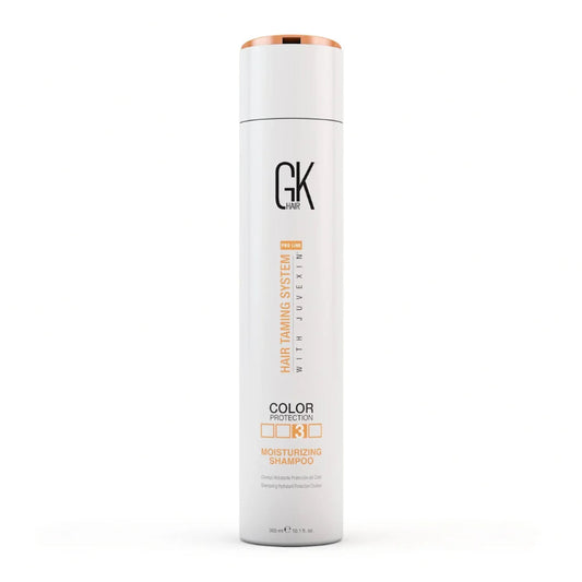 A tall white cylindrical bottle of GK Paris Juvexim Hair Taming System 4 Color Protection Moisturizing Shampoo, featuring a metallic rose gold cap and orange and black text on the front, set against a plain white background.