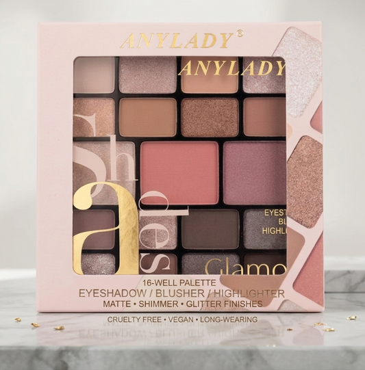 Anylady Glamo 16-well eyeshadow palette in a light pink box with gold lettering, displayed on a marble surface with small gold leaf accents.