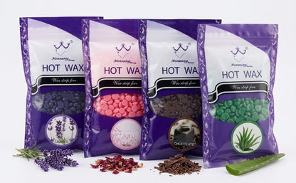 Four stand-up pouches of Nononsense Hot Wax in purple packaging, arranged in a row with botanical ingredients in front: lavender, rose petals, chocolate pieces, and aloe vera. The packages show different wax colors visible through clear windows: dark purple, pink, brown, and green.