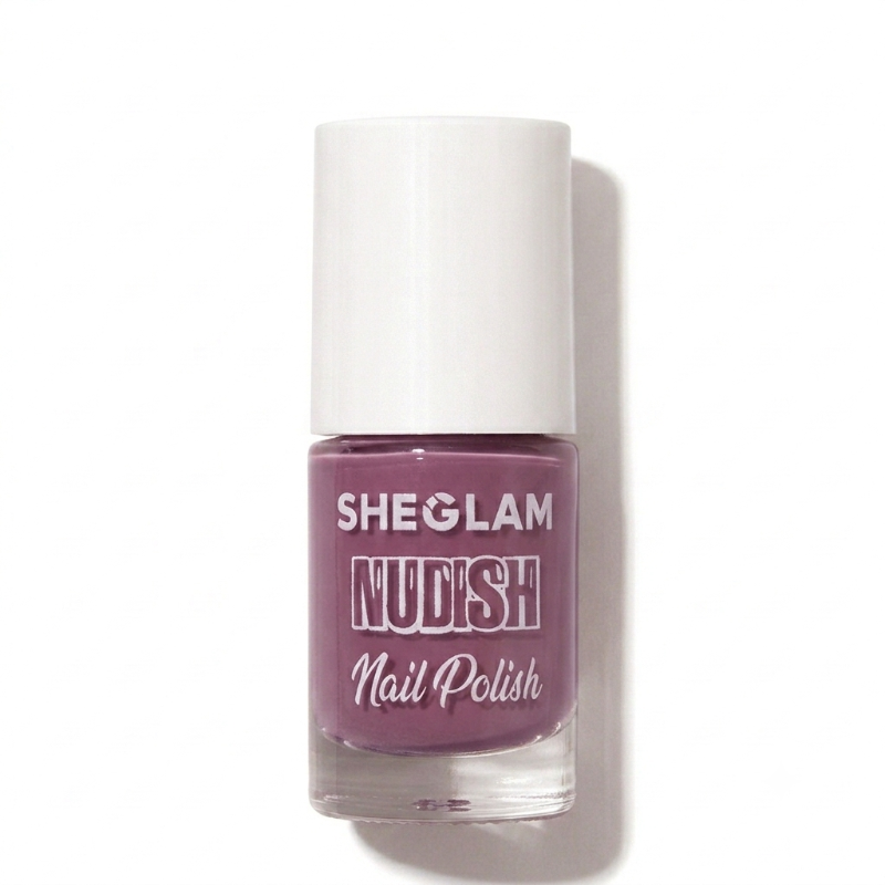 A bottle of SHEGLAM Nudish Nail Polish in a dusty mauve-purple shade, featuring a white cap and clear glass bottle, set against a plain white background with a soft shadow.